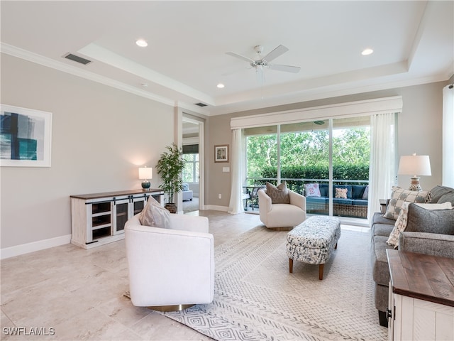 living room featuring crown molding, a raised ceiling, and ceiling fan