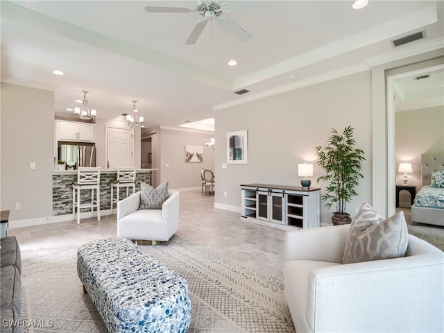 living room with ceiling fan with notable chandelier and ornamental molding