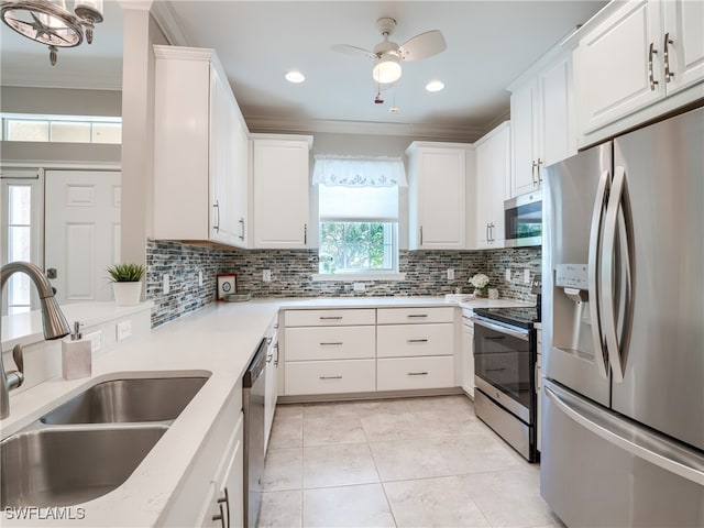 kitchen with white cabinets, crown molding, appliances with stainless steel finishes, sink, and ceiling fan