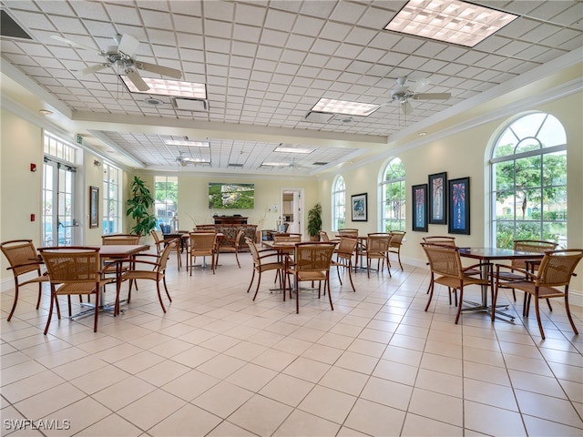 tiled dining room with ceiling fan and ornamental molding