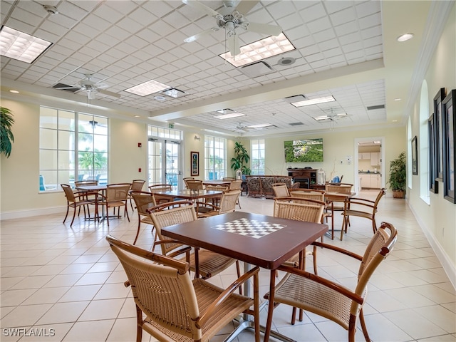 tiled dining space with crown molding, a healthy amount of sunlight, and ceiling fan