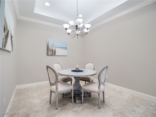 dining room with a tray ceiling, ornamental molding, and an inviting chandelier