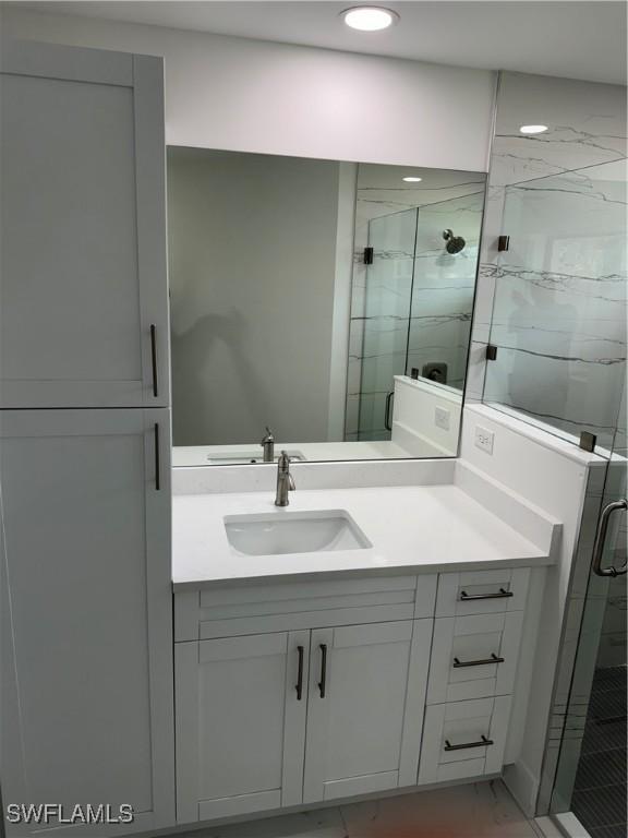 bathroom with vanity and a shower with door