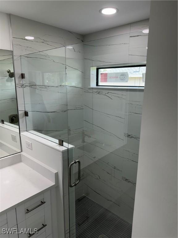 bathroom featuring vanity and an enclosed shower