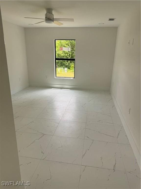 spare room with light tile patterned floors and ceiling fan