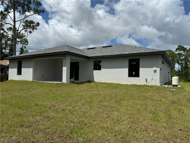 rear view of property with a lawn