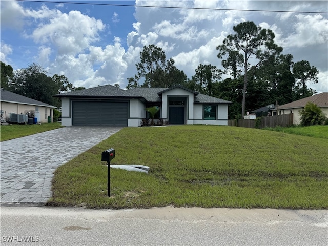 single story home featuring central air condition unit, a garage, and a front lawn