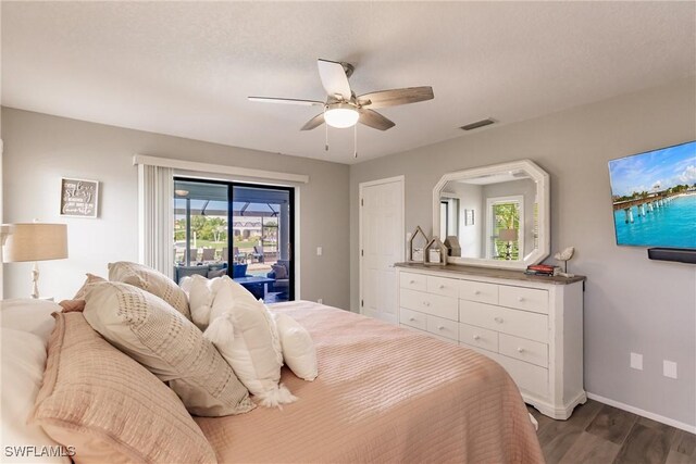 bedroom featuring dark hardwood / wood-style flooring, multiple windows, access to outside, and ceiling fan