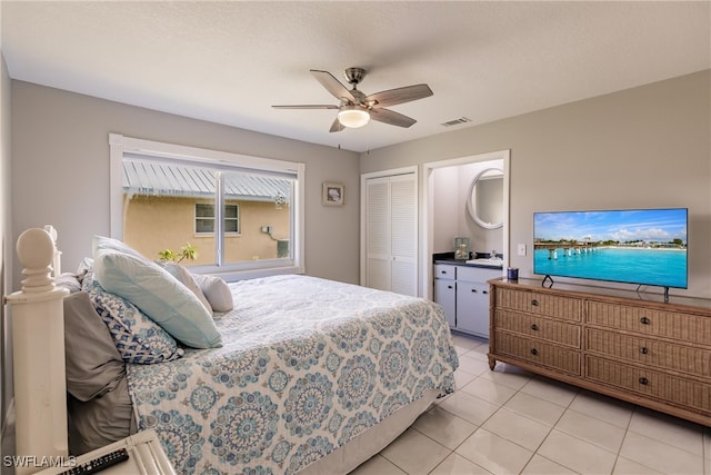 bedroom featuring light tile patterned flooring, sink, ceiling fan, and a closet