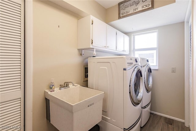 laundry area featuring separate washer and dryer, sink, dark hardwood / wood-style floors, and cabinets