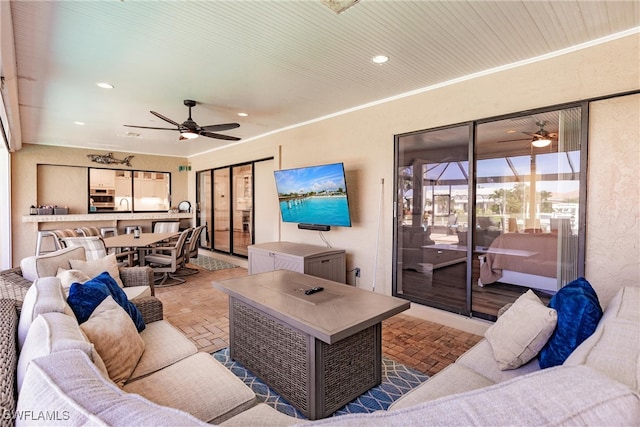 living room with ornamental molding, sink, and ceiling fan