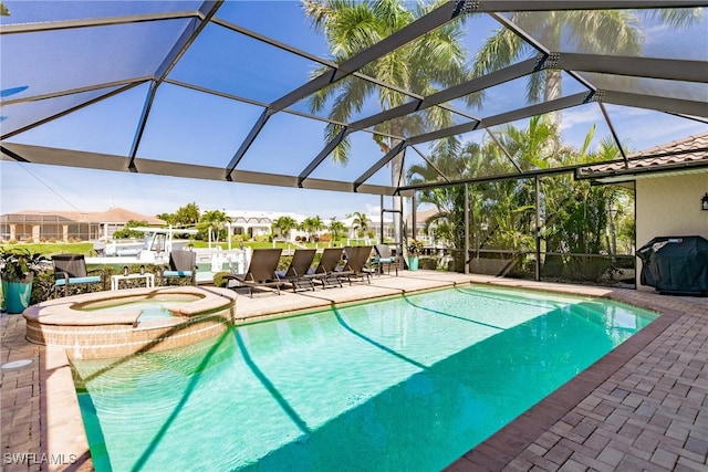 view of pool featuring an in ground hot tub, a patio area, area for grilling, and a lanai