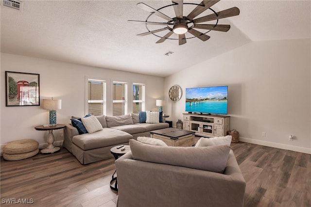 living room with lofted ceiling, hardwood / wood-style floors, a textured ceiling, and ceiling fan