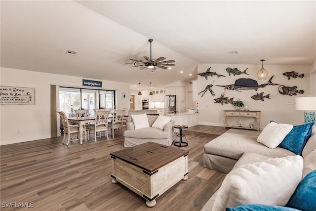 living room with lofted ceiling, ceiling fan, and dark wood-type flooring