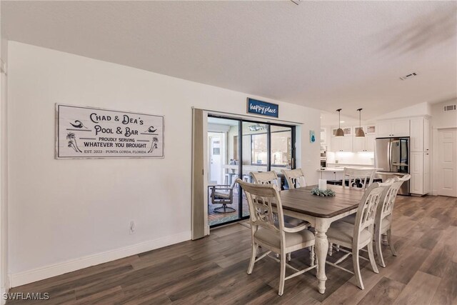 dining area with wood-type flooring and lofted ceiling