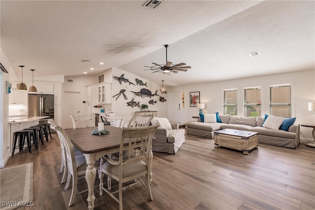 dining room featuring ceiling fan, a textured ceiling, and hardwood / wood-style flooring