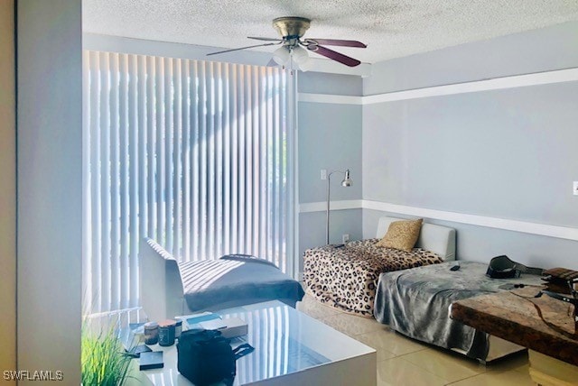 bedroom with a textured ceiling, ceiling fan, and light tile patterned floors