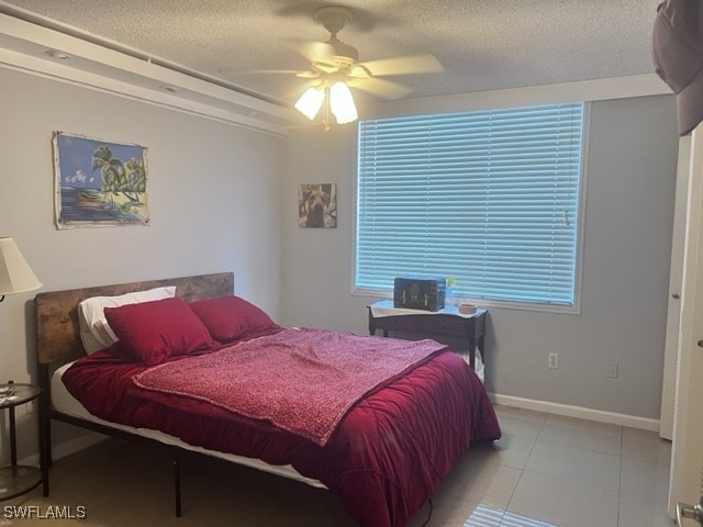 tiled bedroom featuring ceiling fan and a textured ceiling