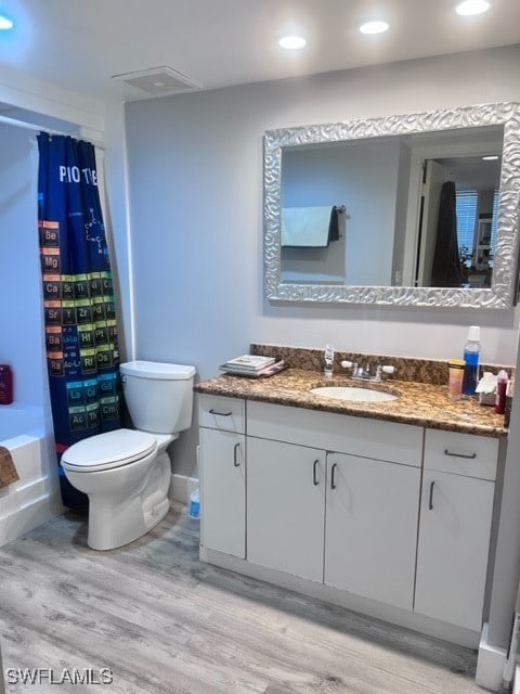 full bathroom featuring shower / tub combo with curtain, vanity, wood-type flooring, and toilet