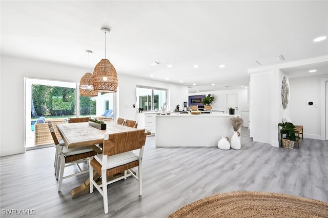 dining room with light hardwood / wood-style flooring and a healthy amount of sunlight