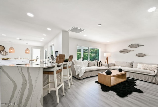 living room with sink and light hardwood / wood-style flooring