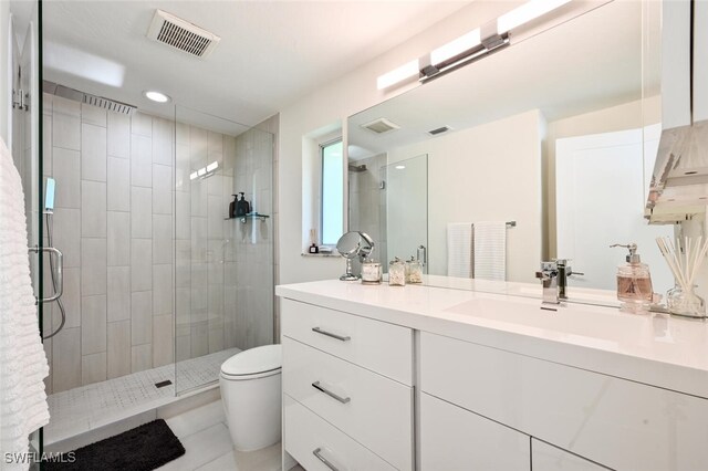 bathroom featuring vanity, toilet, an enclosed shower, and tile patterned flooring