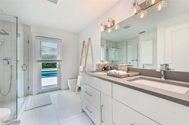 bathroom with vanity, tile patterned floors, and a shower with shower door