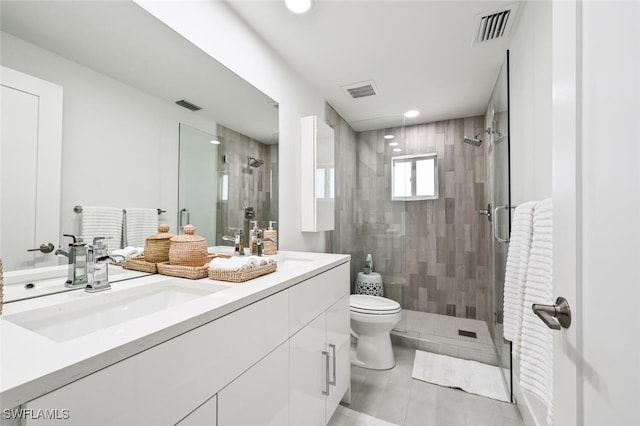 bathroom featuring vanity, tile patterned flooring, a shower with door, and toilet