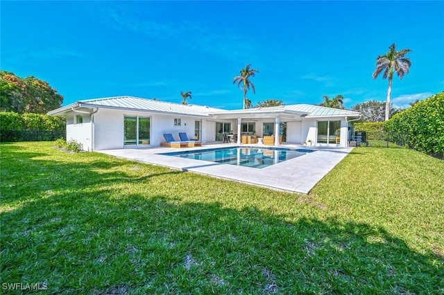 rear view of property with a yard and a patio area