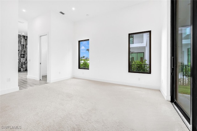 empty room with light carpet, visible vents, baseboards, and recessed lighting