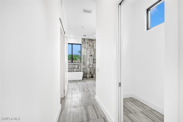 hall with recessed lighting, visible vents, and baseboards