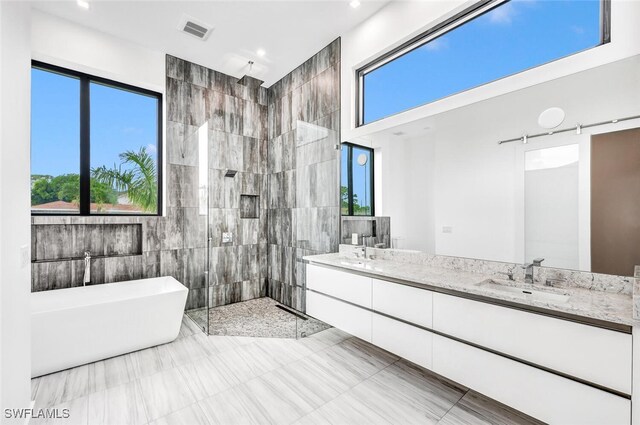 bathroom featuring vanity, shower with separate bathtub, and tile walls