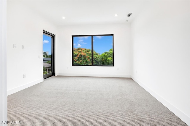 spare room with recessed lighting, light colored carpet, visible vents, and baseboards