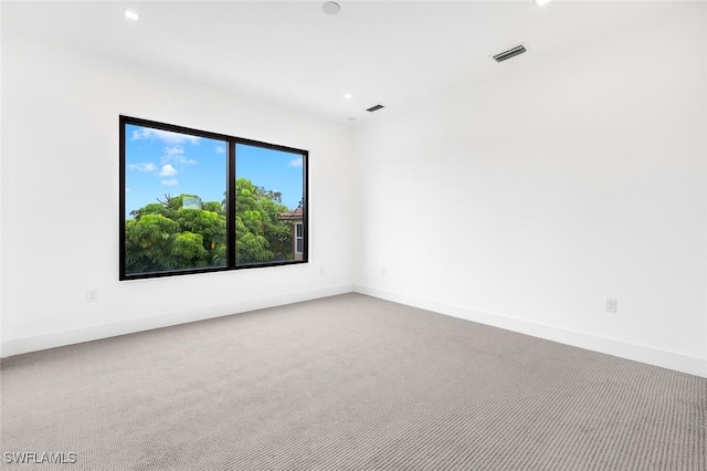 carpeted empty room featuring recessed lighting, visible vents, and baseboards