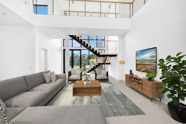 living room with stairway and a towering ceiling