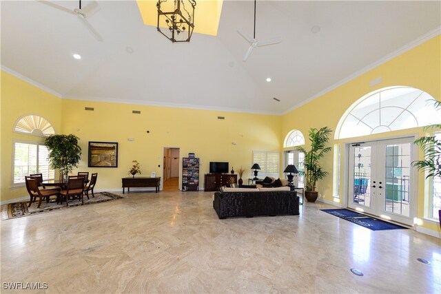 living room featuring light tile patterned flooring, french doors, ornamental molding, and ceiling fan with notable chandelier