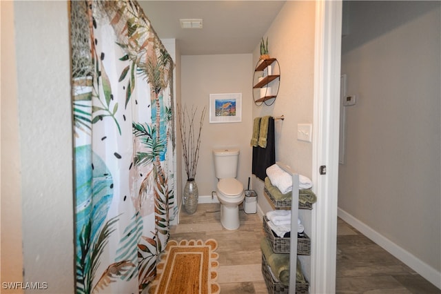 bathroom featuring hardwood / wood-style floors and toilet