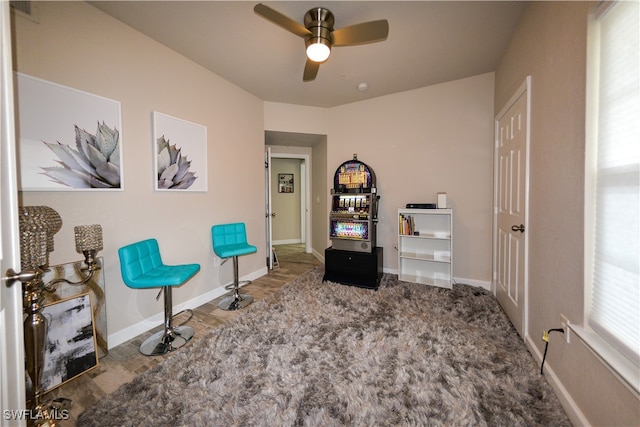 sitting room with ceiling fan and wood-type flooring