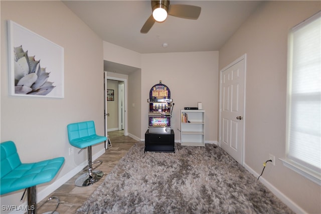 living area with ceiling fan, plenty of natural light, and light hardwood / wood-style floors