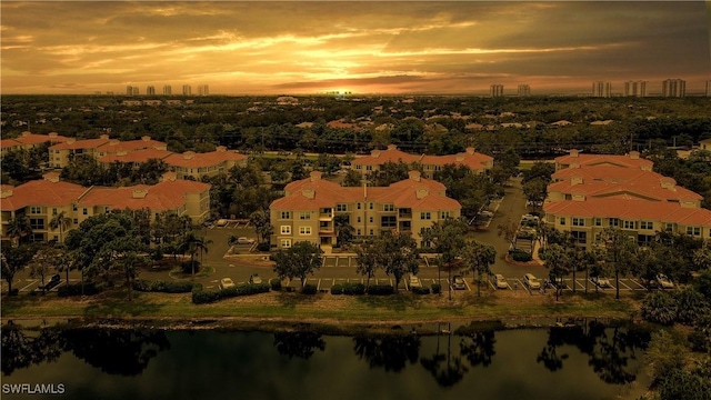 aerial view at dusk featuring a water view