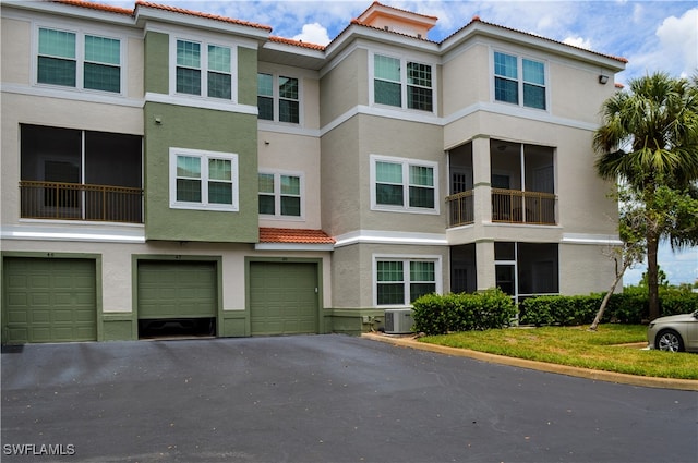 exterior space featuring central AC unit, a garage, and a balcony