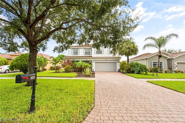 view of front of house with a garage, decorative driveway, and a front yard