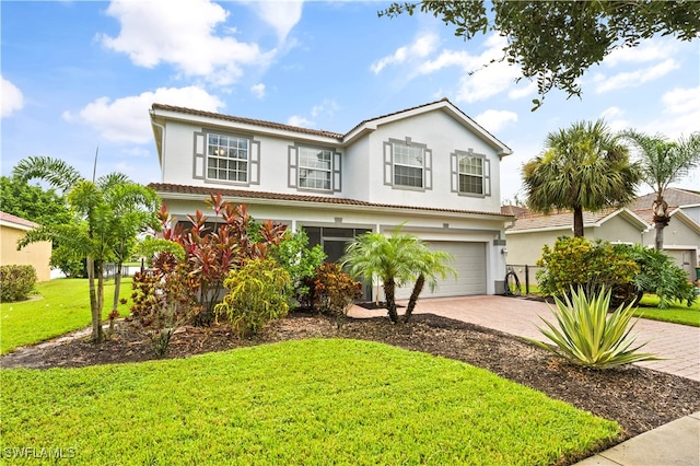 view of front of house with a garage, decorative driveway, a front yard, and stucco siding