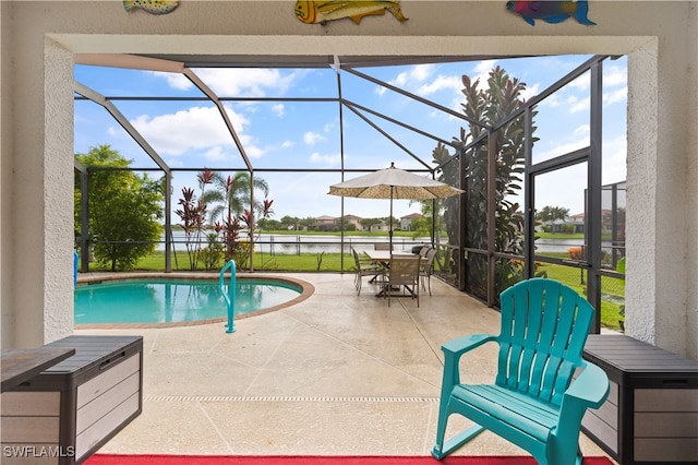 outdoor pool featuring glass enclosure, a patio, and a water view