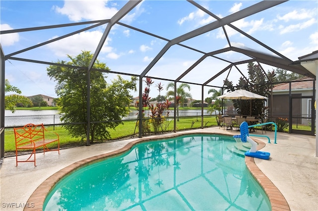 outdoor pool with a patio area, glass enclosure, and a water view