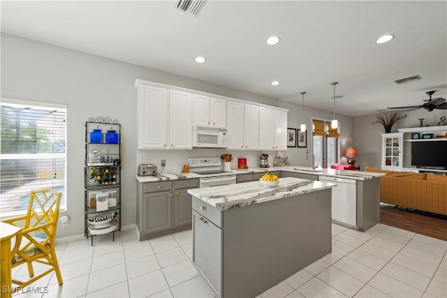 kitchen with decorative light fixtures, open floor plan, white cabinetry, white appliances, and a peninsula