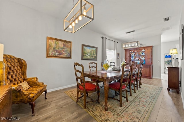 dining area featuring light wood-type flooring, baseboards, and visible vents