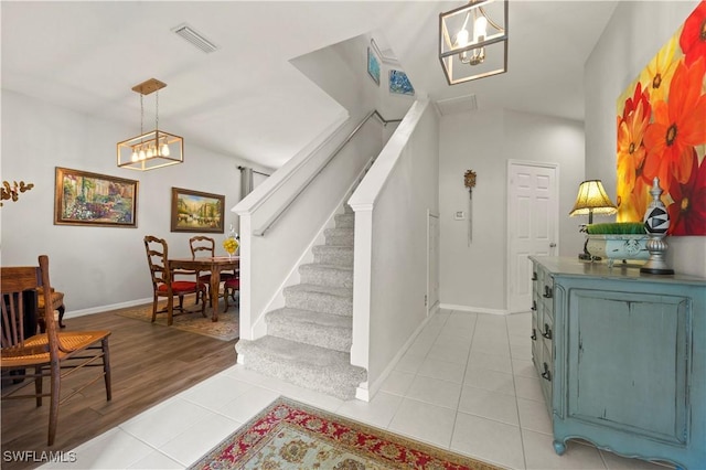 stairway with tile patterned flooring, visible vents, and baseboards