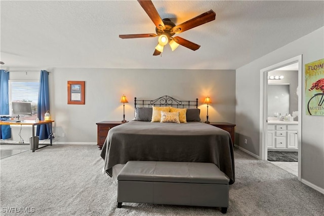 bedroom with light carpet, a textured ceiling, baseboards, and connected bathroom