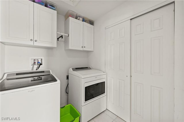 laundry area featuring light tile patterned flooring, independent washer and dryer, and cabinet space